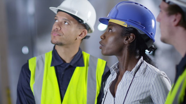  Confident female engineer or architect discussing construction issues with male colleagues. 