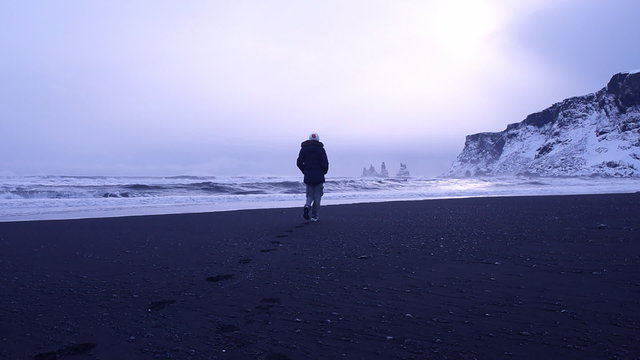 Beautiful young woman walking along black beach of Iceland on sunset, enjoying gorgeous view on Atlantic ocean, Vik Myrdal. Full HD Video 1920x1080
