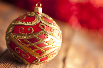 Christmas bauble on wooden and red background