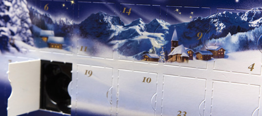 Advent calendar with an open box with a picture of snow and snow-covered houses with mountains in the background
