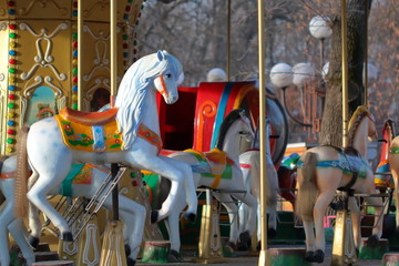 Carousel with horses in City Park in morning sun
