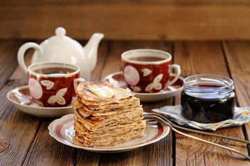 Russian pancakes in heap with jam and black tea
