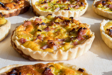 Hand made French quiche lorraine made with bacon, vegetables and eggs, on wooden board