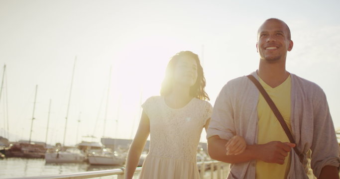 Attractive romantic couple in summertime looking at the boats in the harbor. 