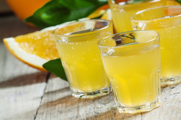 Orange soda on a background of fresh oranges on old wooden table