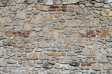 Part of castle wall made of limestone bricks built on white rock