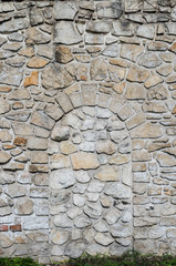 Part of castle wall made of limestone bricks built on white rock