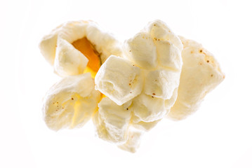 Macro photograph of a piece of popcorn o a blown out white background.