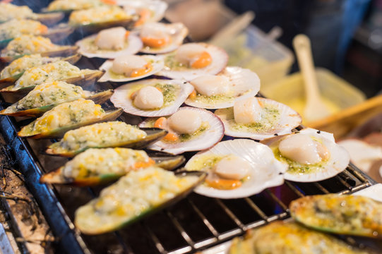 Grilling oysters food on the flaming grill