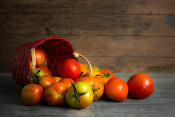 Fototapeta na wymiar juicy red tomatoes in basket on wooden table