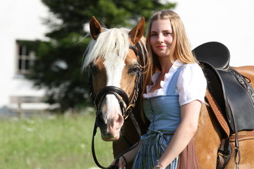 Portrait blondes Mädchen mit Dirndl mit Haflinger
