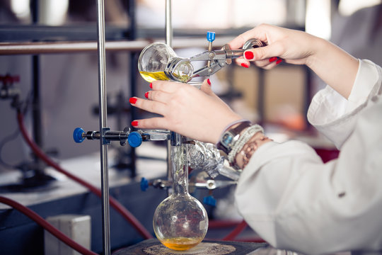 Scientific researcher doing a chemical experiment research.Science students working with chemicals. Chemist doing research with laboratory equipment. Pharmacist performing distillation process