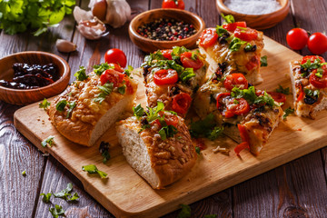 Homemade focaccia with tomatoes, sun-dried tomatoes, mozzarella