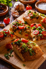 Homemade focaccia with tomatoes, sun-dried tomatoes, mozzarella