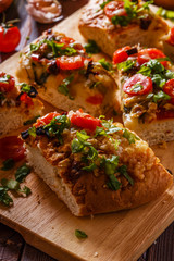Homemade focaccia with tomatoes, sun-dried tomatoes, mozzarella