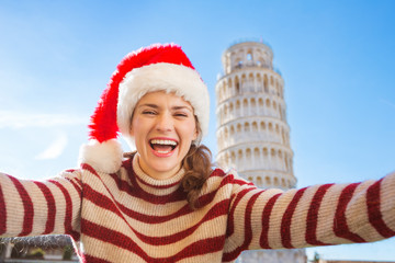 Woman in Santa hat taking selfie in front of Leaning Tour, Pisa