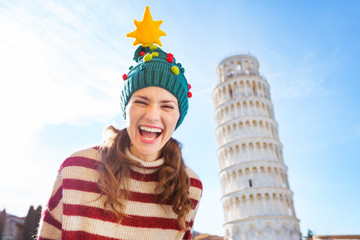 Happy woman in Christmas tree hat near Leaning Tour of Pisa