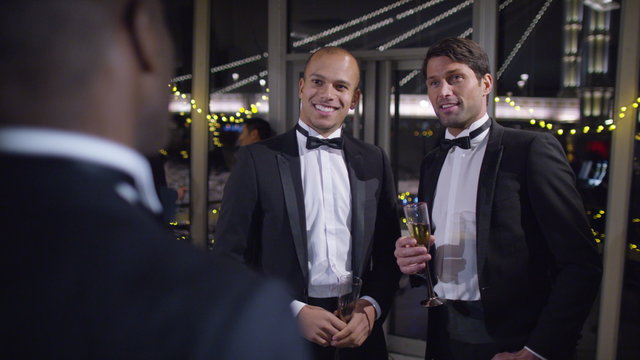  Male friends or business colleagues drinking &chatting at formal social event