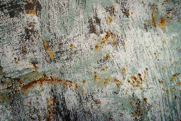 Rusty metal surface with black and aqua paint spots