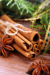 Cinnamon sticks and anise stars with decoration on wooden backgr