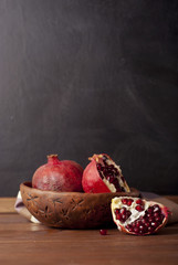 two ripe pomegranate on a wooden rustic background