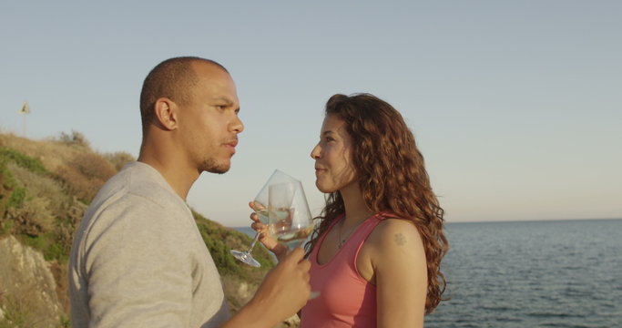  Happy romantic couple drinking wine at outdoor bar or restaurant beside the sea. 