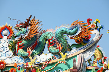 colorful dragon statue against blue sky.