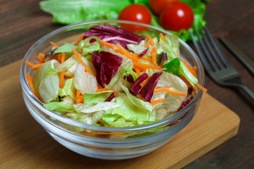 salad with lettuce and carrots on a wooden background