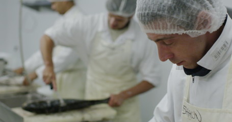 Workers in a seafood processing factory preparing fresh fish for sale
