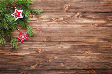 Christmas decorative stars and balls and fir branches on wooden background