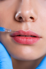 Naklejka premium Cosmetic injection on the pretty woman face. Isolated on gray background