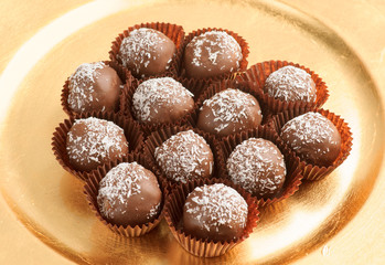 balls of chocolate covered coconut on golden tray