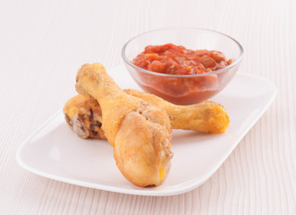 tray with two chicken legs and hot sauce