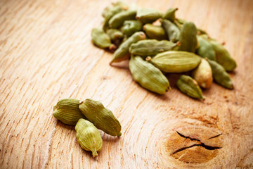 Green cardamom pods on wooden background