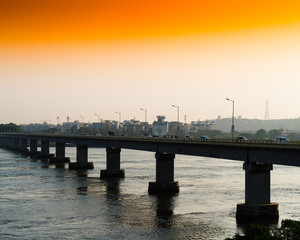 Fototapeta na wymiar Horizontal vivid orange sunset indian bridge background backdrop