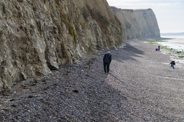 People walking on Cote d'Opale coast with white cliffs near Audresselles, France