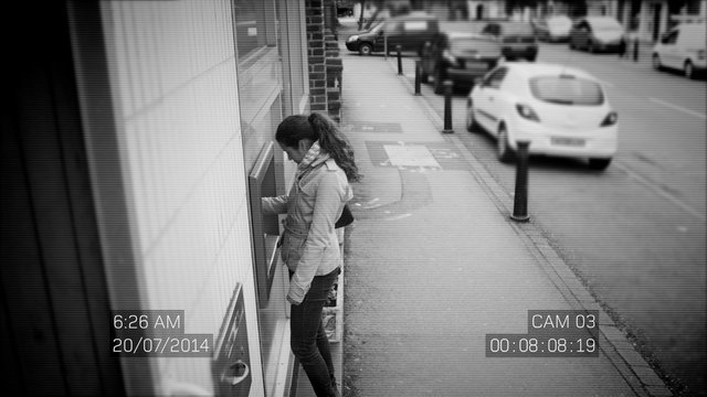 CCTV footage of suspicious woman taking cash from an ATM machine