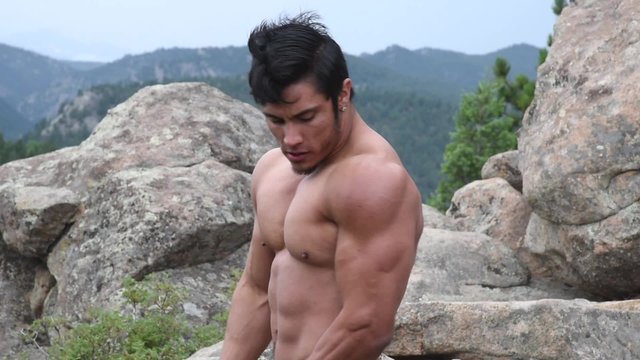Handsome male bodybuilder flexing outdoors
