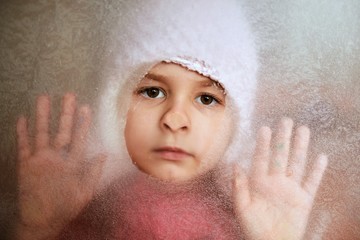 Little girl behind a frozen window