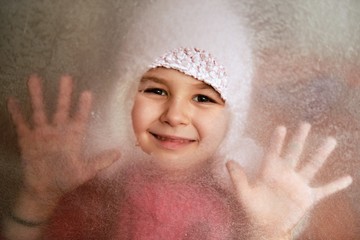 Little girl behind a frozen window
