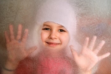 Little girl behind a frozen window