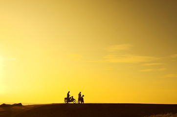Fototapeta na wymiar silhoutte of a man standing with his bike during beautiful golde