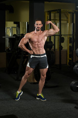 Fototapeta na wymiar Serious Body Builder Standing In The Gym