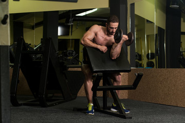 Obraz na płótnie Canvas Muscular Man Exercising Biceps With Dumbbell