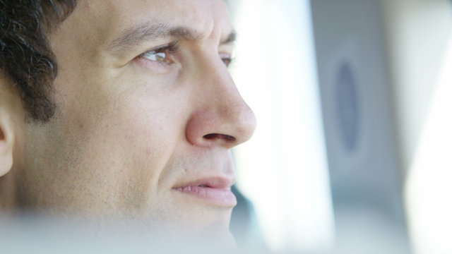 Close-up of businessman working on laptop and drinking coffee on train journey