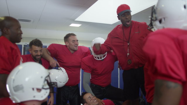  American football coach in locker room, psyching up players before the game