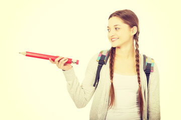 Schoolgirl pointing aside with pencil.