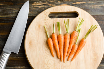 Fresh carrots on wooden plate ready for cooking