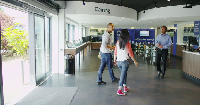 Couple shopping in consumer electronics store showroom