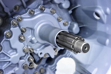 Gear shaft of automotive transmission with grey nuts, bolts and blue color coating, gearbox for oversize trucks, SUV, cargo, commercial and construction vehicles, selective focus 